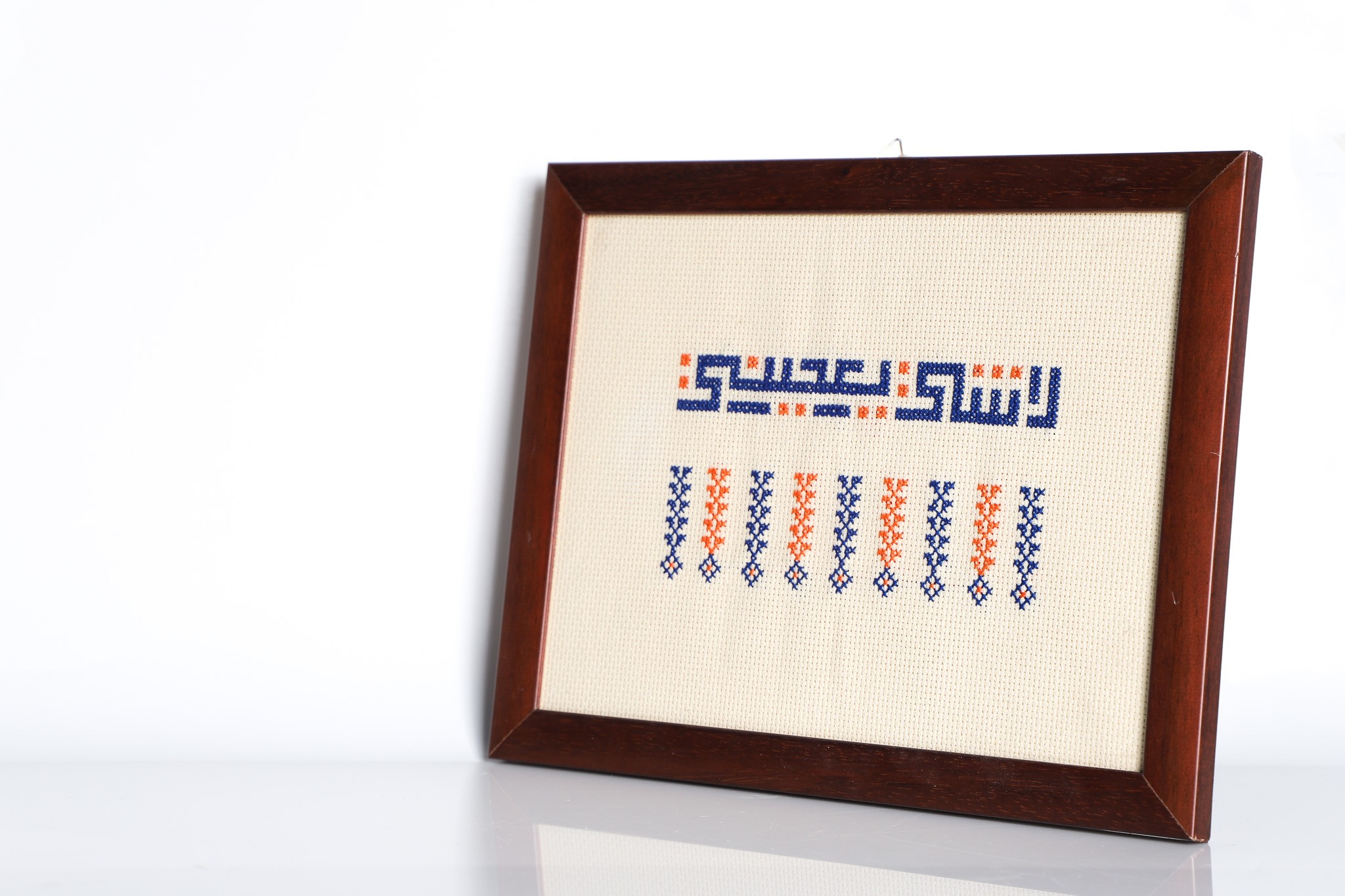An embroidered frame with Kufic calligraphy.