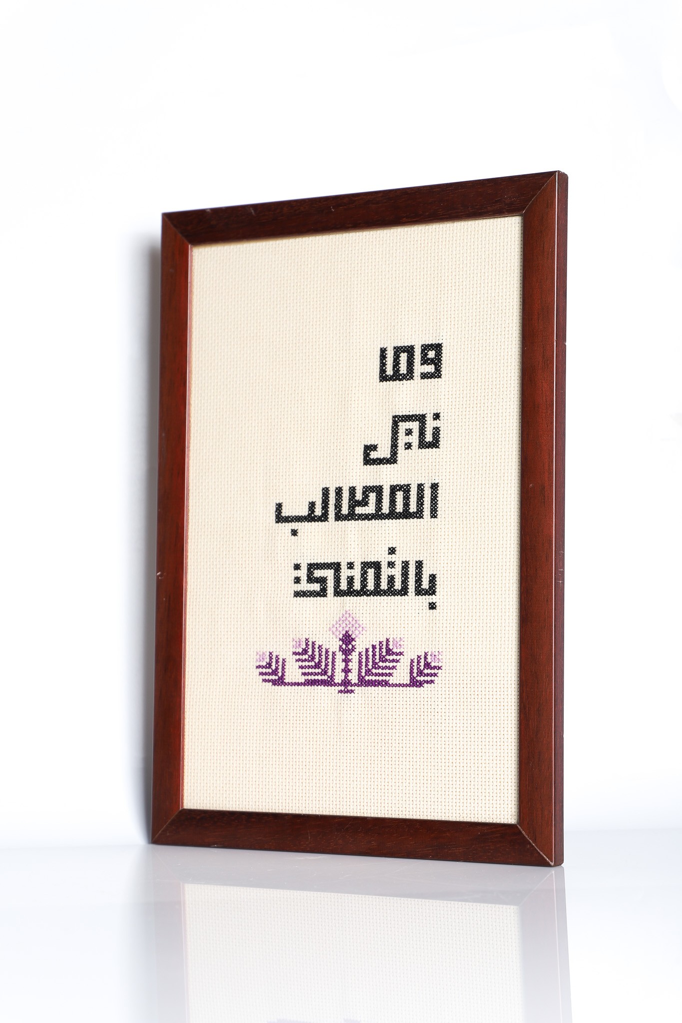 An embroidered frame with Kufic calligraphy.