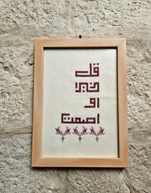 An embroidered frame with Kufic calligraphy.