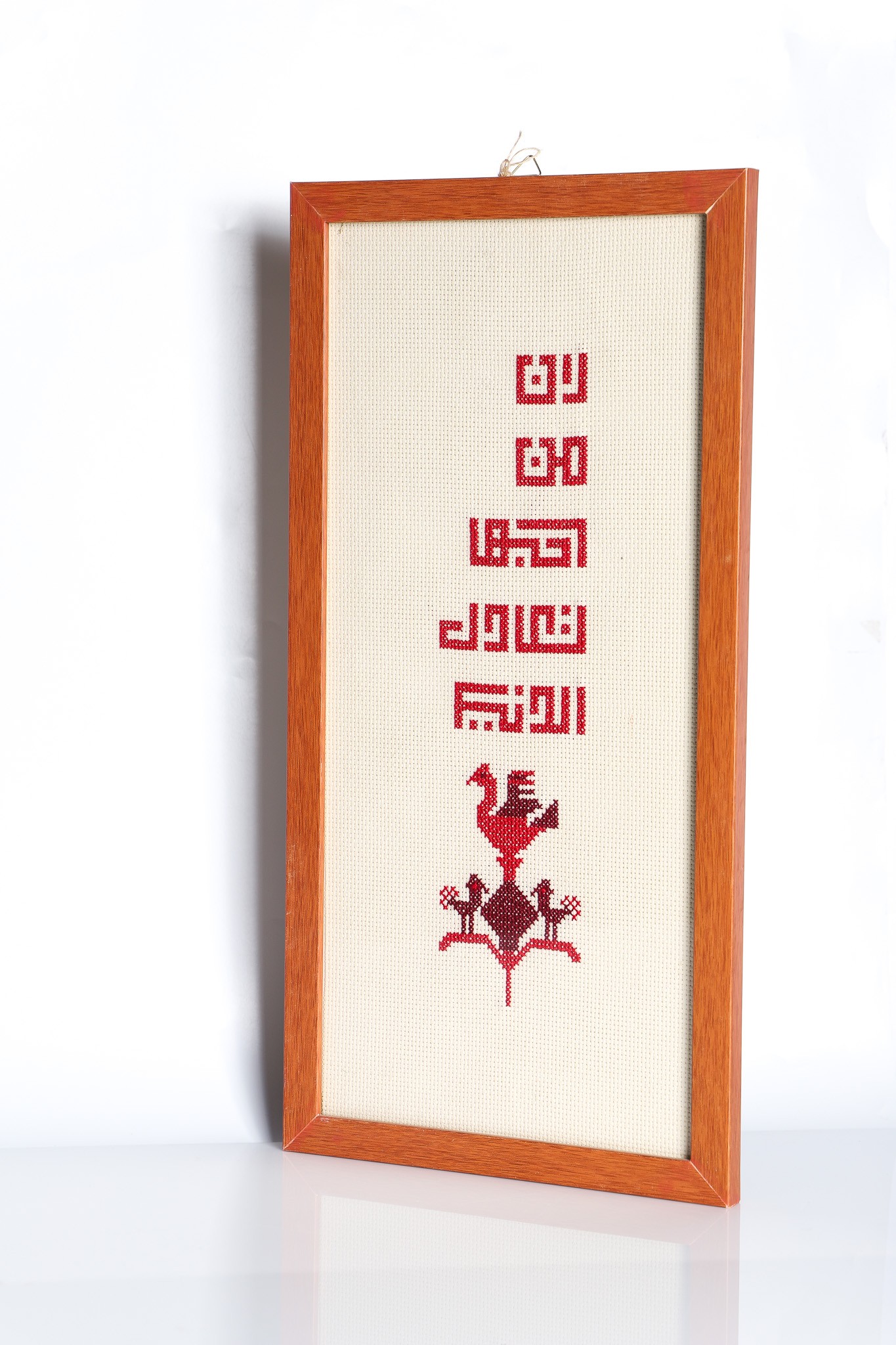 An embroidered frame with Kufic calligraphy.