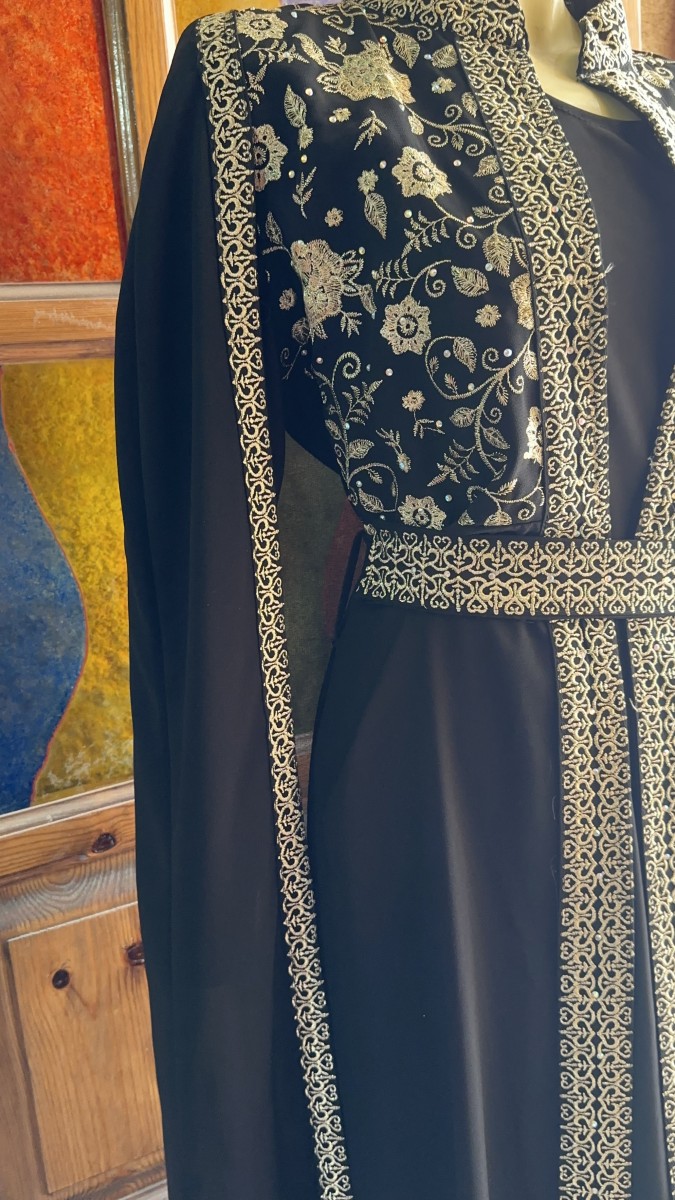 A timeless black abaya adorned with exquisite oriental golden embroidery — the perfect choice for brides and special occasions.