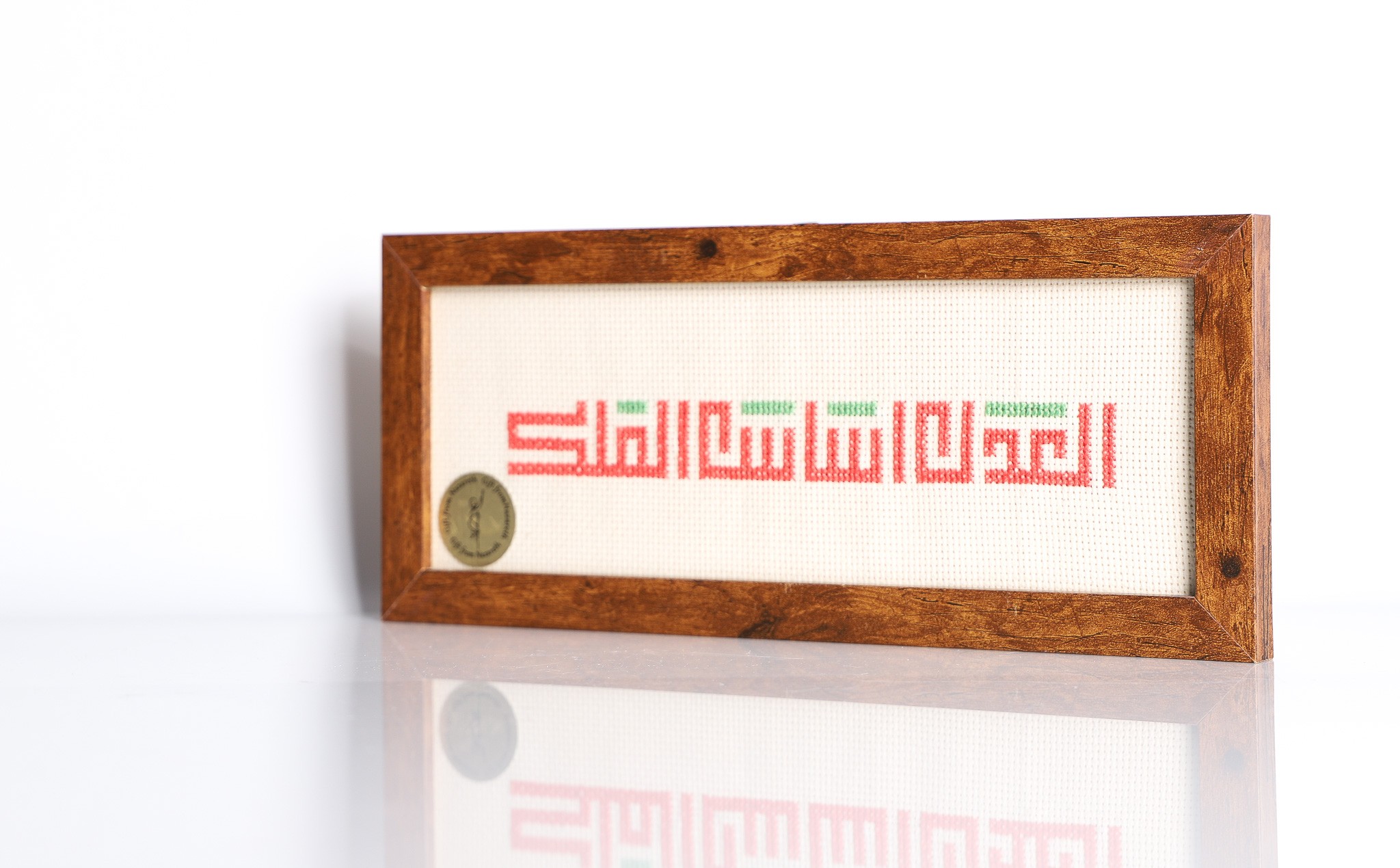 An embroidered frame with Kufic calligraphy.