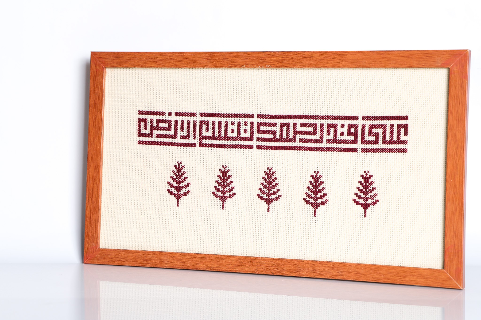 An embroidered frame with Kufic calligraphy.